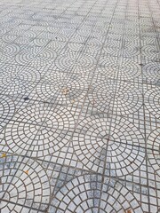 Grey concrete paving slabs with decorative concentric circle design for urban architecture and street infrastructure