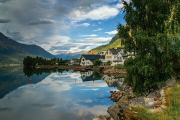 Fototapeta premium view of the idyllic village of Hjelle on the shores of the Oppstsrynsvatnet Lake in central Norway