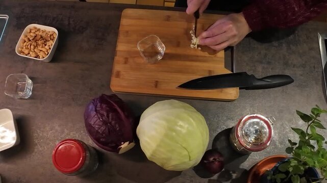 Knoblauchzehe mit einem Messer klein schneiden