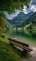 Serene mountain lake scene featuring a bench, lush foliage, and towering peaks under a cloudy sky