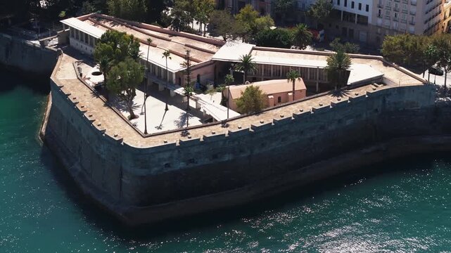 Aerial drone shot in Cadiz in Spain, Andalusia, Europe, on bright sunny day, facing Baluarte de la Candelaria. Commercial grading