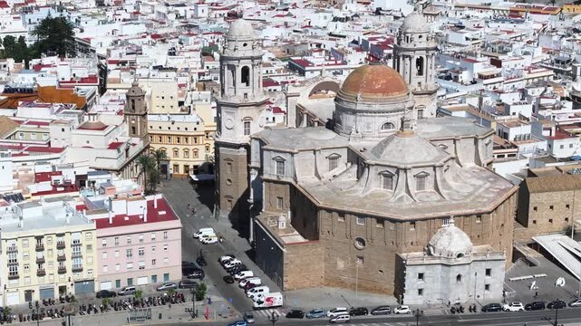 Aerial drone cityscape view of C&aacute;diz in Spain, Andalusia, Europe, on bright sunny day, facing C&aacute;diz cathedral and waterfront. Drone orbiting