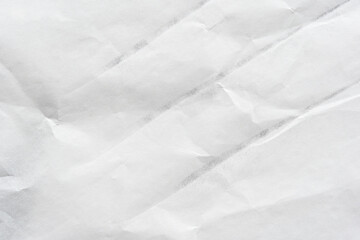 Crumpled white paper texture with folded lines and wrinkles for background and design.