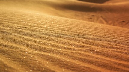 Fototapeta premium Natural desert landscape background showing wind-swept sand dunes texture with crystalline highlights in a warm gold to copper gradient.