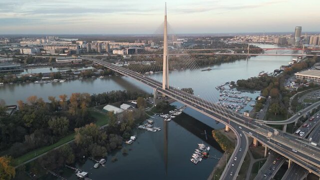 Aerial perspective showcases a picturesque view of Ada bridge spanning the Sava river in Belgrade, Srbija. Golden hour.