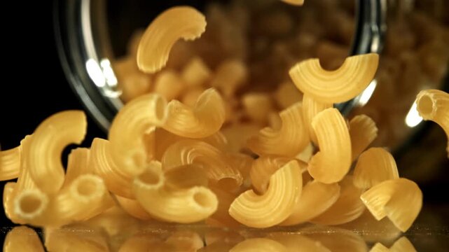 Super slow motion dry macaroni pasta . Filmed on a high-speed camera at 1000 fps. High quality FullHD footage