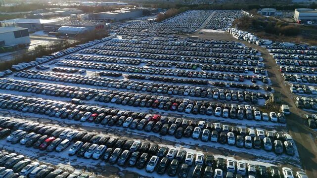 Aerial view of rows of cars parked at the BCA car storage facility under a dusting of snow, creating a stark contrast, Corby, United Kingdom.