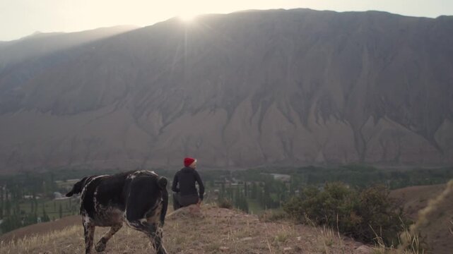 Girl with a dog in the mountains in Kyzyl Oi Village, Kyrgyzstan