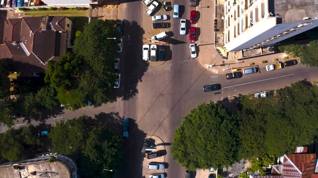 Aerial view of the intersection with cars, buildings and trees creating a vibrant contrast between urban structures and natural elements, Maputo, Mozambique.