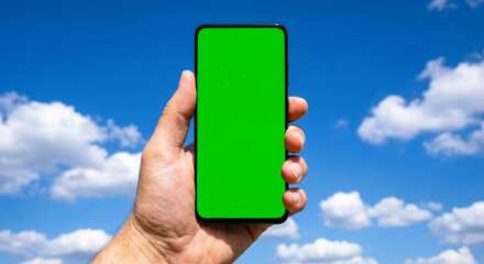 Hand Holding Smartphone with Green Screen Against Blue Sky