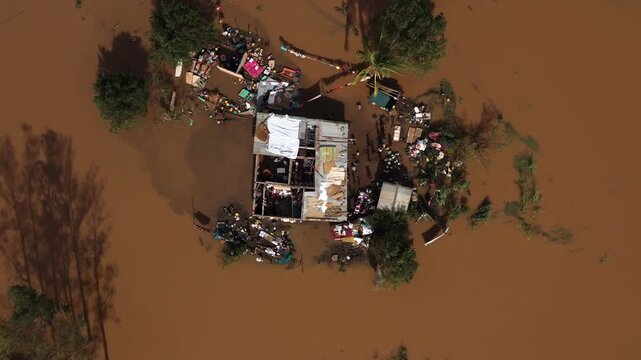 Aerial view of a flooded house surrounded by debris and muddy water, showcasing the devastating impact of floods, Beira, Sofala Province, Mozambique.