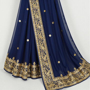 Deep blue sari with gold zari and sequin border, draped on white with ornate floral motifs