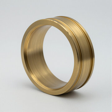 Polished brass large-caliber cartridge case ring with deep cannelure grooves, displayed on a white background