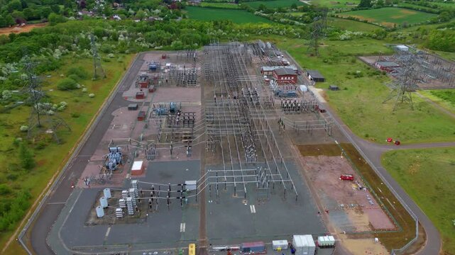 Aerial view of the Wymondley electrical sub station, a network of power lines and equipment contrasting with the lush green fields, Wymondley, Hitchen, United Kingdom.