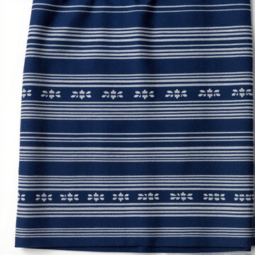 Indigo woven Laotian sinh skirt with white striped bands and floral motifs, folded on white background