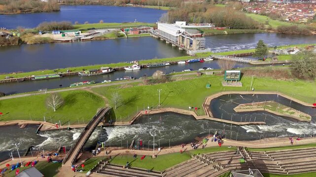 Aerial view of the vibrant waters of Colwick Sluice contrast with the lush green landscape, a picturesque scene of nature and engineering, Colwick, Nottingham, United Kingdom.
