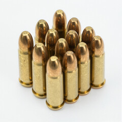 Cluster of shiny brass pistol cartridges standing upright on a white background