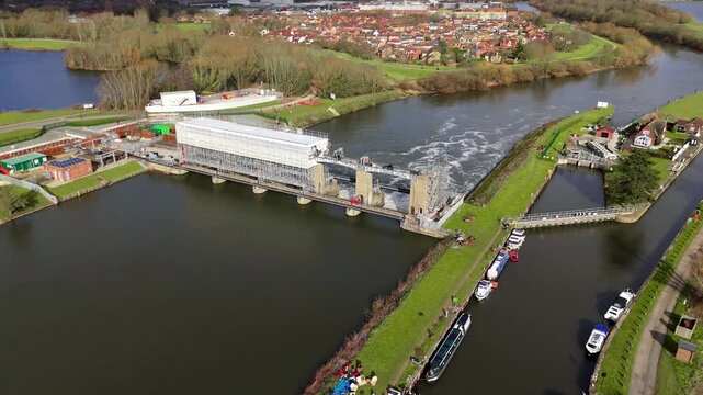 Aerial view of Colwick Sluice revealing the waterway, the bridge, and the surrounding landscape in muted tones, Colwick Sluice, Nottingham, United Kingdom.