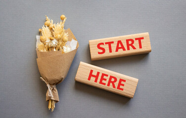 Start here symbol. Wooden blocks with words Start here. Beautiful grey background. Business and Start here concept. Copy space.