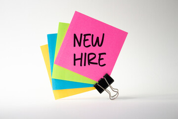 New Hire symbol. Pink sticky note with concept words New Hire. Beautiful white background. Business and New Hire concept. Copy space.