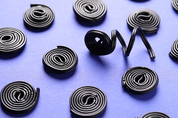 Natural licorice candies on violet background, closeup