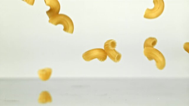 Super slow motion dry macaroni pasta . Filmed on a high-speed camera at 1000 fps. High quality FullHD footage