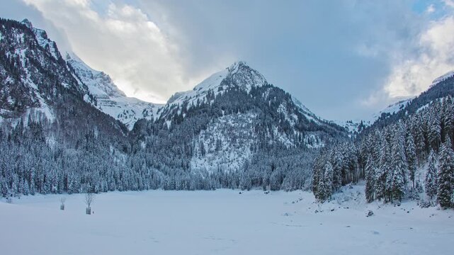 Time lapse, snowy mountain landscape, lake covered by snow. Lake Voralpsee, Canton of St. Gallen, Switzerland