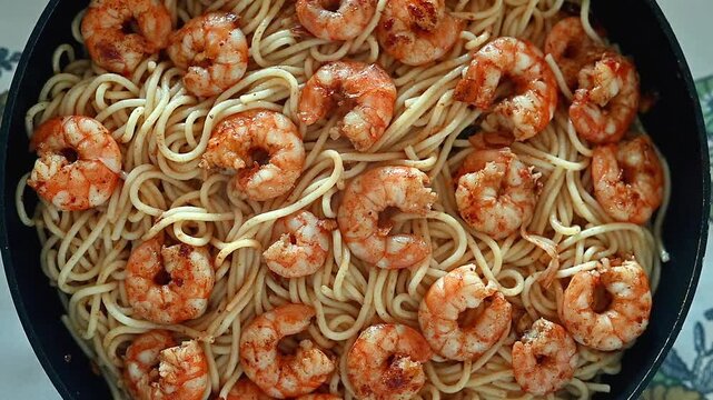 Delicious spaghetti with shrimp and prawns in olive oil and garlic with pil pil sauce, freshly cooked in a pan at home , seafood recipes and homemade spicy meals