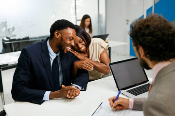 Happy couple meeting financial advisor at office