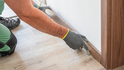 Installing elegant plastic baseboard, showcasing skilled craftsmanship in home improvement and...