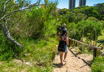 A woman is walking on a path in a forest