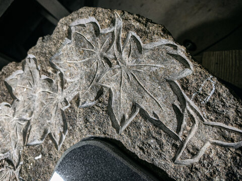maple leaves carved in rough granite stone