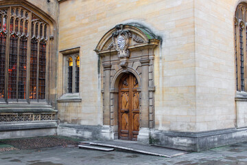 Naklejka premium The ornate Gothic entrance to the Divinity School in Oxford. It features intricate stonework and tall stained-glass windows, a historic site known for its use as a Harry Potter filming location.