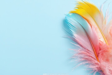 Obraz premium Vibrant feather quill in pastel colors on light blue background, creating cheerful and artistic atmosphere