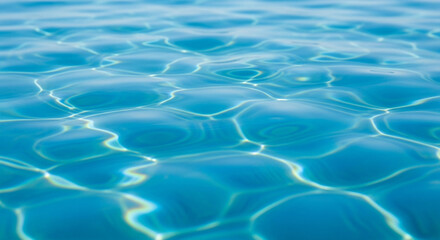 Fototapeta premium Rippling water surface in serene blue tone with shimmering sunlight reflections for abstract background