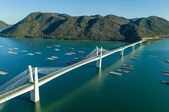 Winter aerial view of Bizen Hinase Bridge and oyster farming rafts in Seto Inland Sea, Japan.