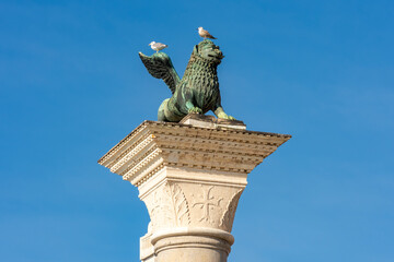 Winged lion sculpture (symbol of Venice) on San Marco column at St. Mark's square, Venice, Italy
