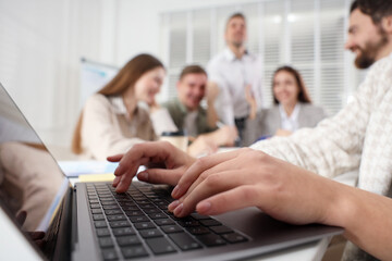 Businesspeople working together at table in office, selective focus