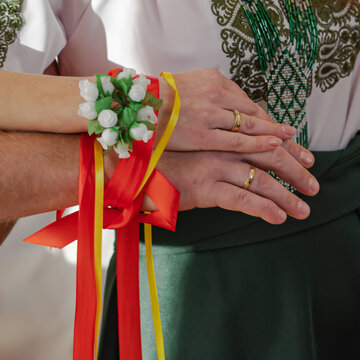 Wedding handfasting ritual with ribbons and flowers, close-up
