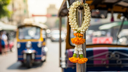 Garland of fresh Thai jasmine flowers hanging from tuk-tuk in city  