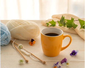 Warm Coffee Mug with Knitted Cozy and Yarn on Wooden Table 
