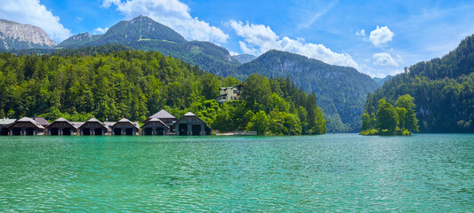 Schöner Panoramablick auf den Königssee, mit den Bootshäusern und einer kleinen Insel.