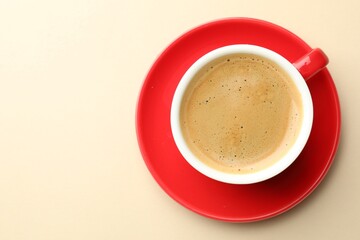 Cup of aromatic coffee on beige background table, top view. Space for text