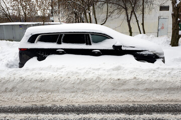 Heavy snowfall. The blizzard has covered the roads. Cars are stuck in snowdrifts.