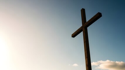 Wooden cross against a clear blue sky with clouds