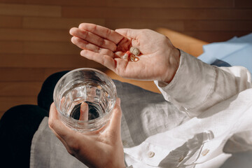 Person Holding Pills And Glass Of Water In Calm Home Setting For Health And Wellness