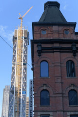 Naklejka premium architectural contrast: Gloucester Mews (an historic commercial/residential block at the northeast corner of Yonge St and Gloucester St in downtown Toronto) and The One Bloor St W