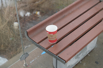 Naklejka premium discarded Tim Hortons beverage cup inside a bus shelter seat, Toronto