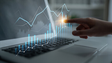 A dynamic scene showcasing a person hand interacting with a laptop displaying rising financial graphs, symbolizing growth and analysis in today business world. Scalp