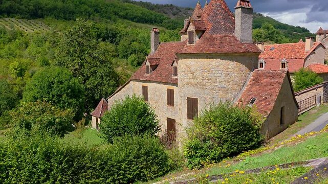 Beautiful medieval building in the valleys of the Lot region of France. Handheld upward panning motion.